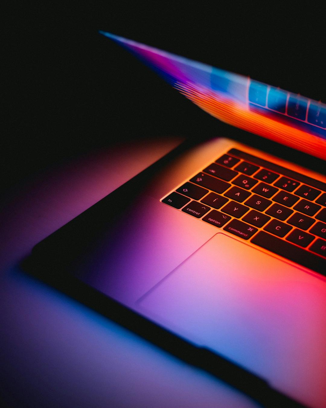 macbook half open lighting up keyboard with vivid colors